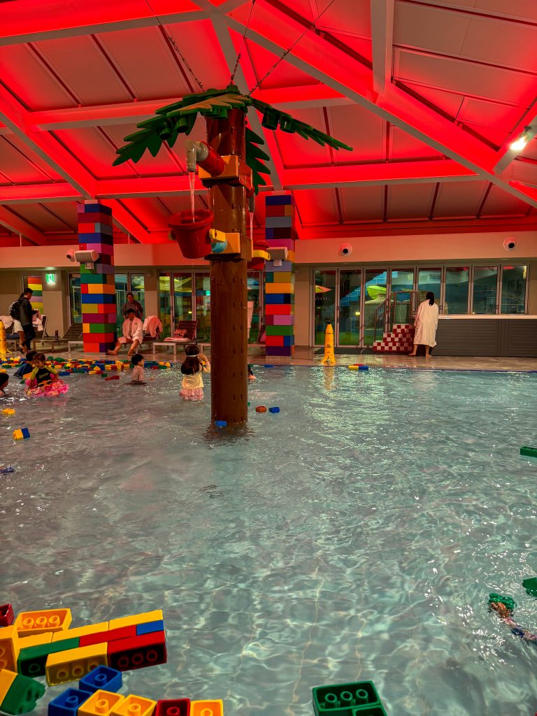Lego themed swimming pool with a lego palm in the middle of the pool