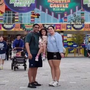 Dad, Mum and Daughter Standing outside the Front of Leogland Korea as they consider moving abroad
