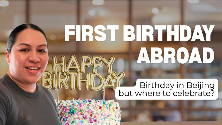 A lady smiling at the camera on the left hand side, with a white cake decorated in confetti and a small decoration on top that says Happy Birthday in gold, next to the words "First Birthday Abroad" and "Birthday in Beijing, but where to Celebrate"