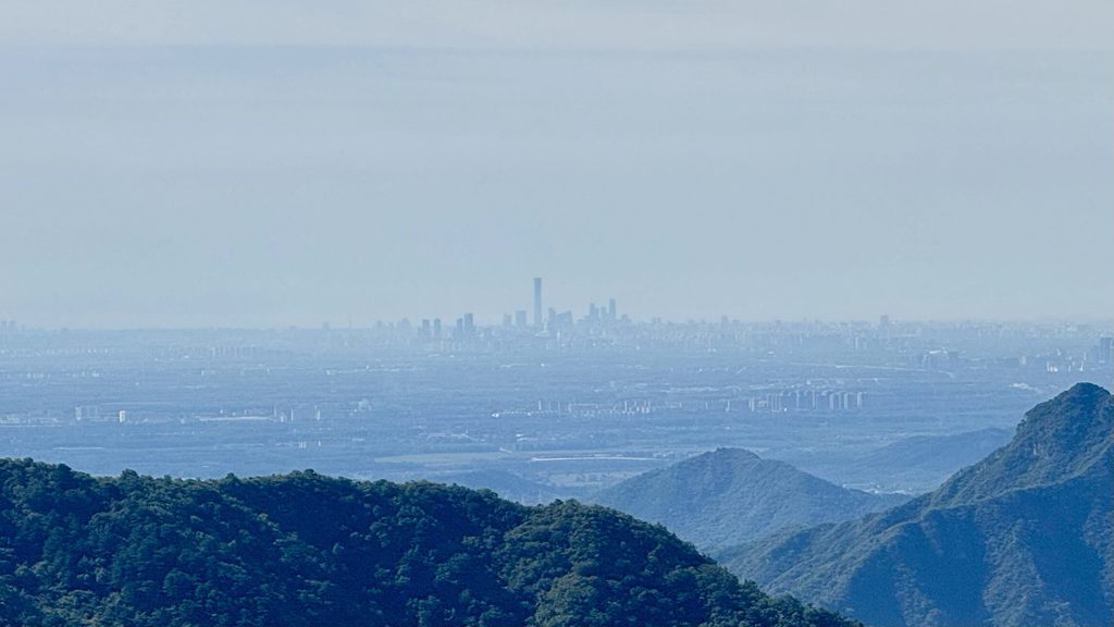 Beijing skyline in the distance, seen from the mountains at Mutianyu Great Wall