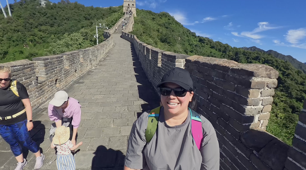 Family walking along the Mutianyu Great Wall with a toddler on a sunny day