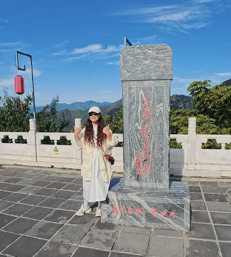 Woman posing beside the stone marker at the Mutianyu Great Wall
